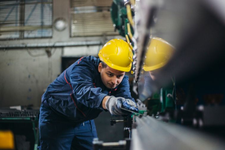 A factory worker inspecting a machine